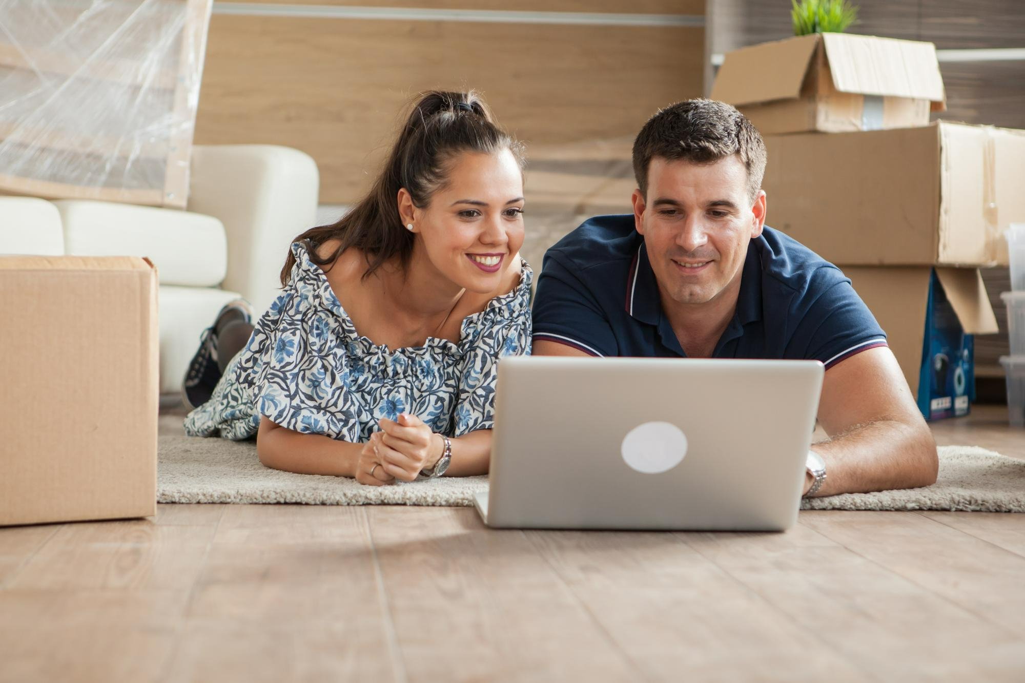 young couple notifying organizations of change of address during moving into new home