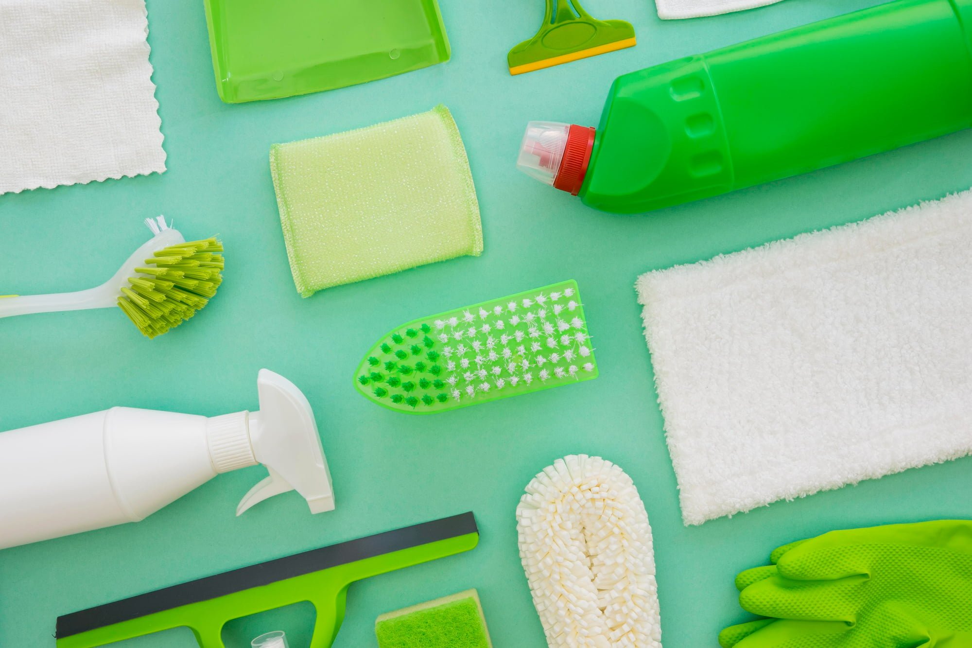 disinfecting supplies with green background to show green cleaning tips for your apartment