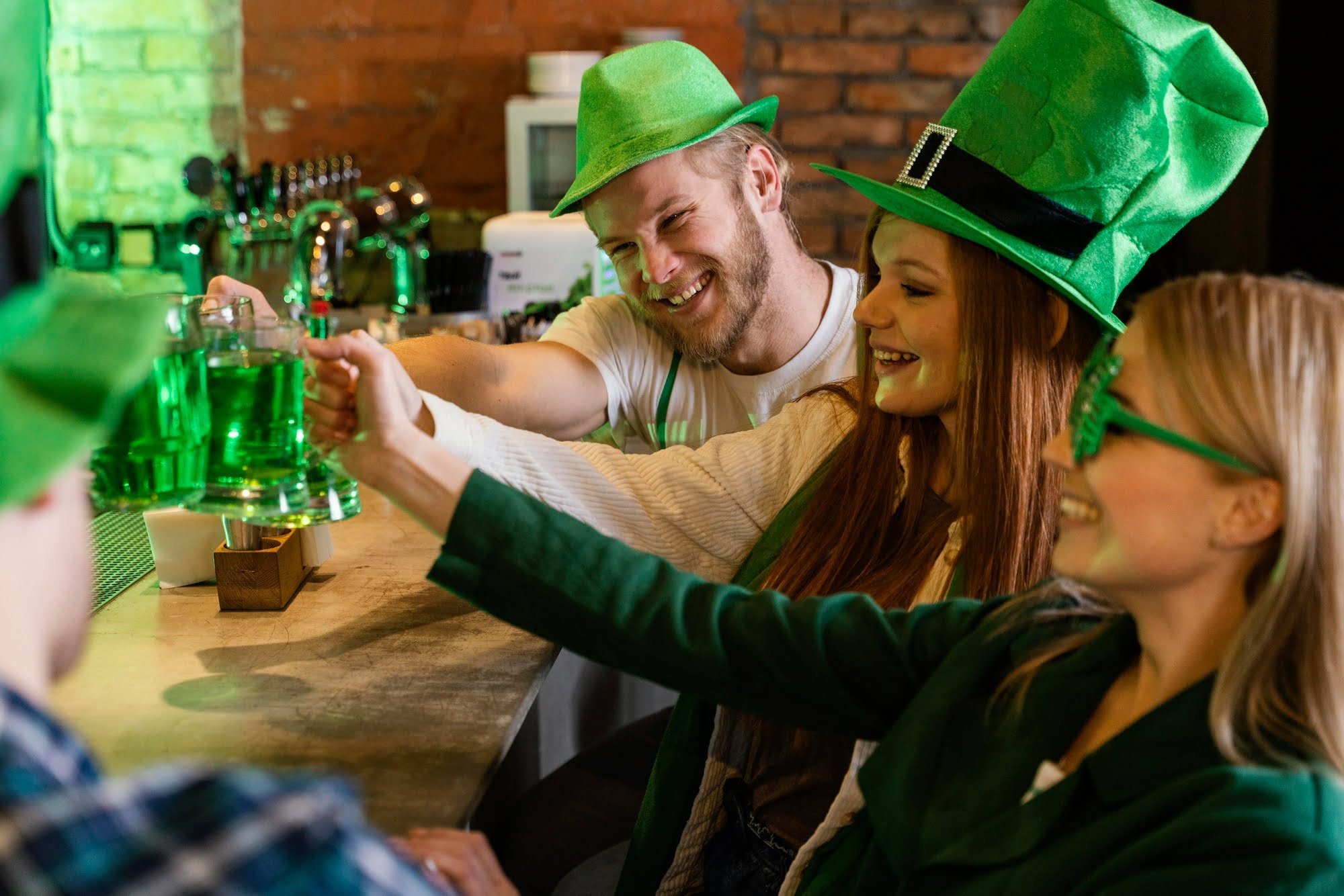 friends cheersing at a local bar with green beer wearing green accessories at one of the St. Patrick's Day events near Elements at Saratoga Lake